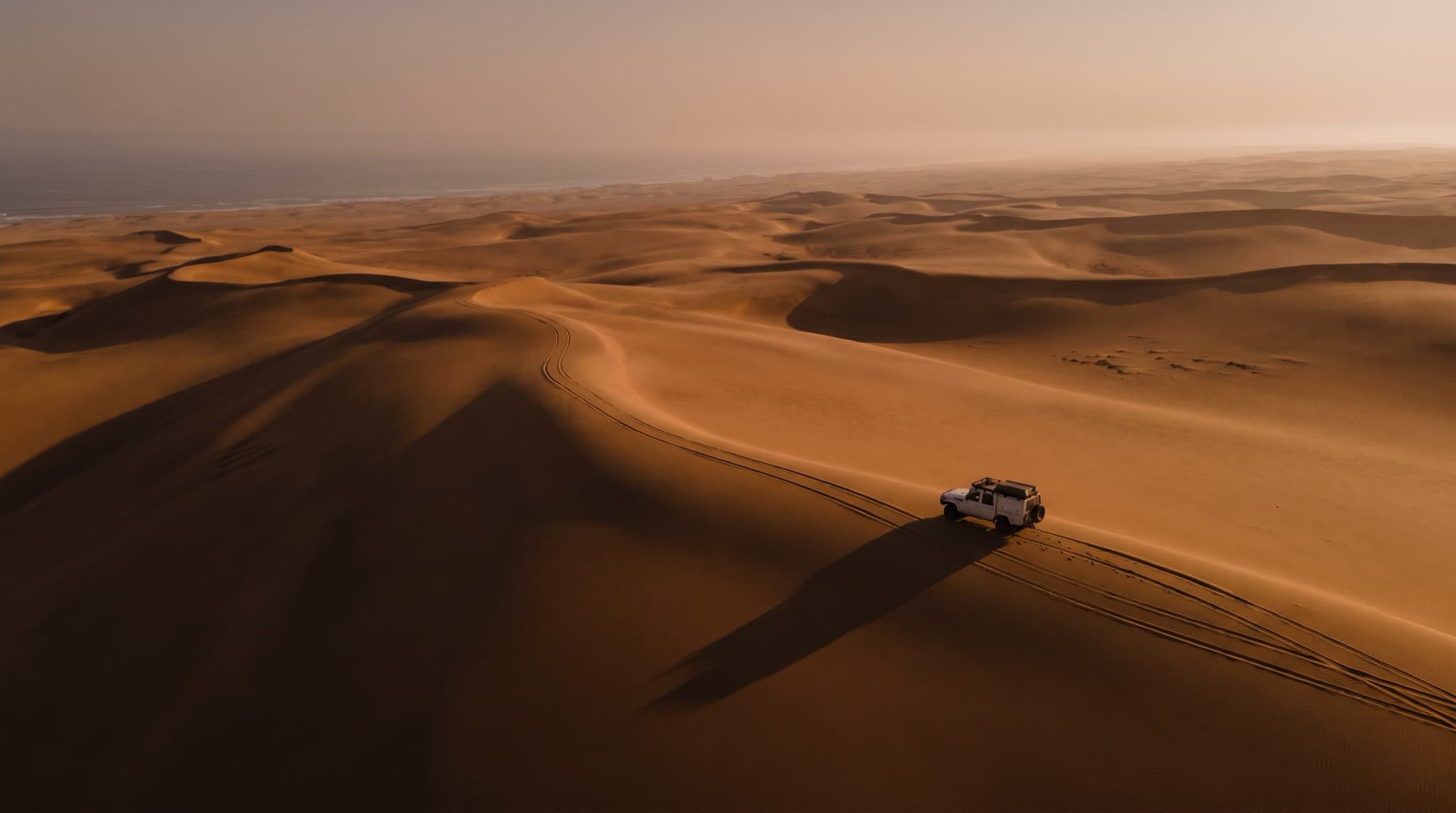 A survey vehicle crossing the dunes of the Namibe desert, Angola